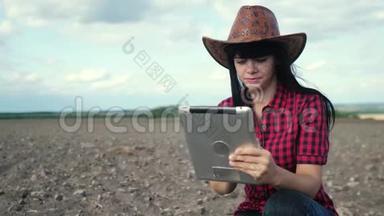 智慧生态是一种收获农业的耕作理念。 女农民用数字生活方式平板电脑研究地球上的泥土